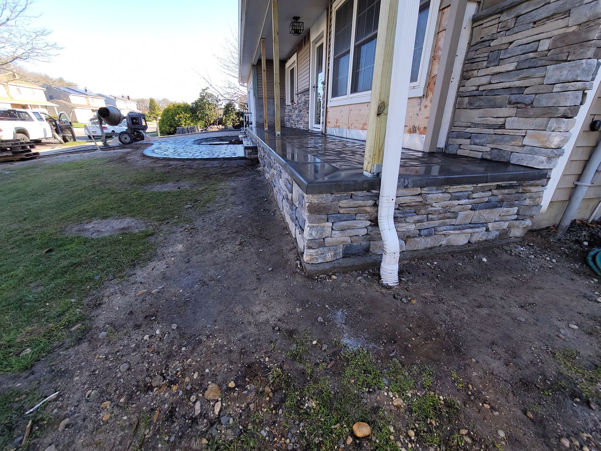 A stone porch is being built on the side of a house.