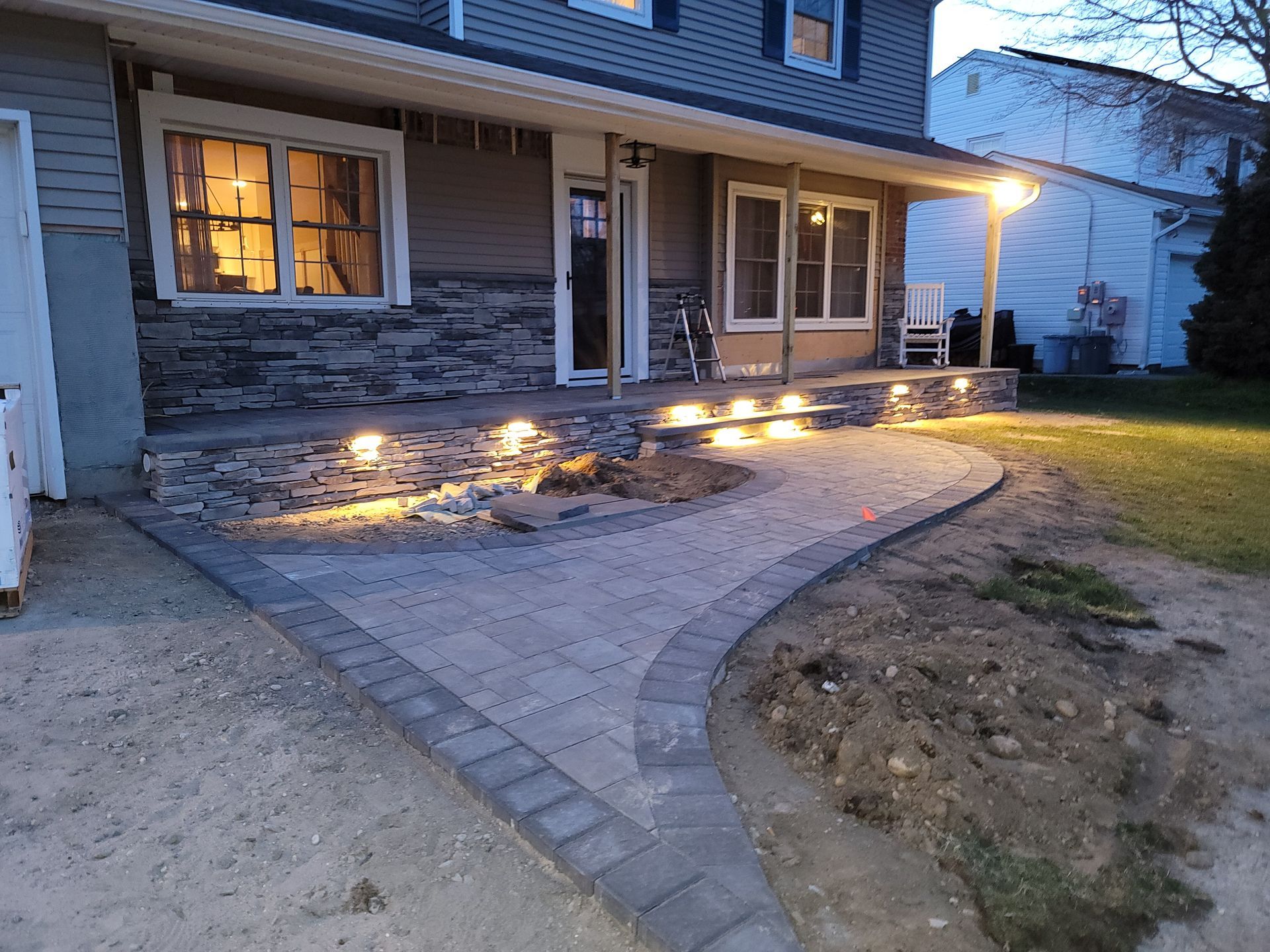 A house with a porch and a walkway with lights on it.