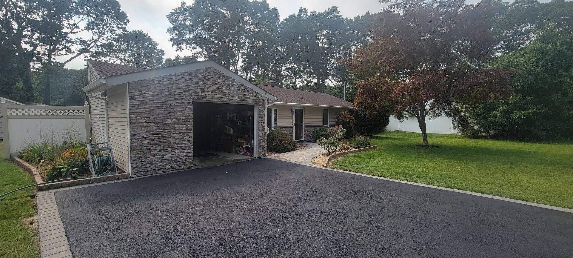 A house with a garage and a driveway in front of it.