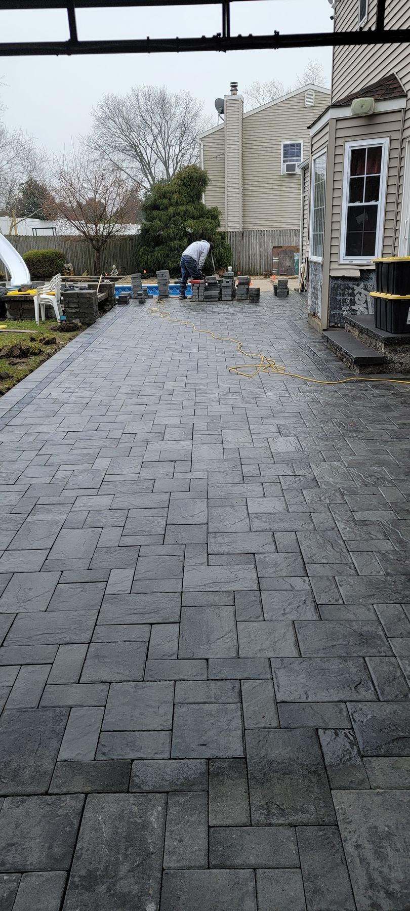A brick walkway is being built in front of a house.