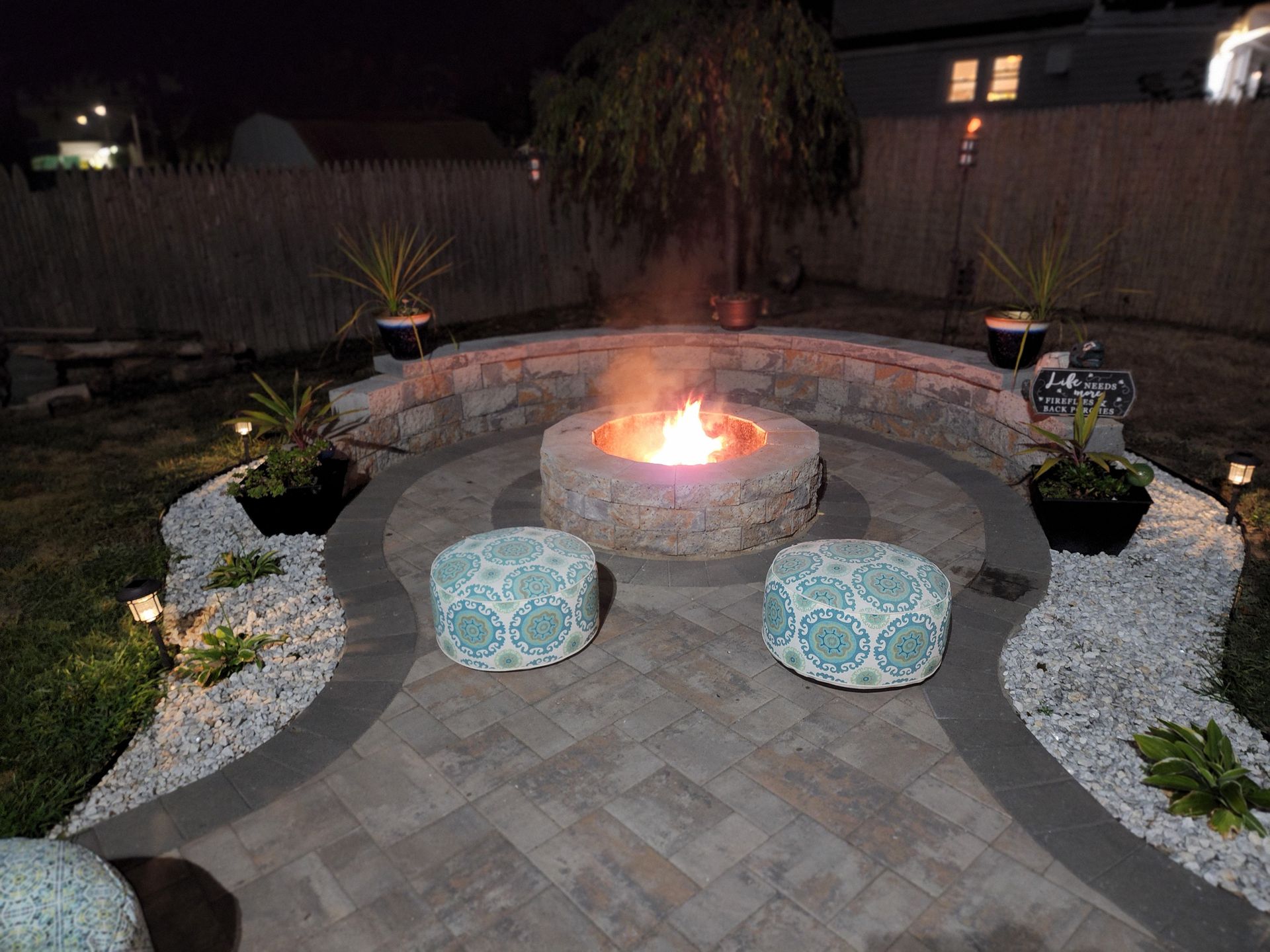 There is a fire pit in the middle of the patio at night.