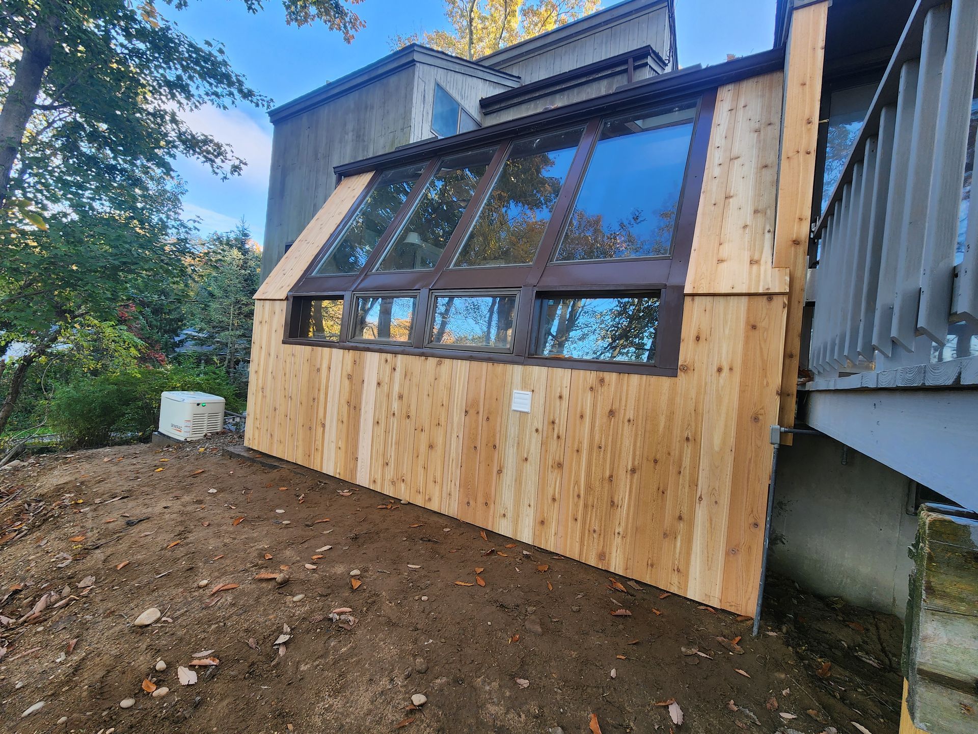 A wooden building with a lot of windows is sitting on top of a dirt hill.