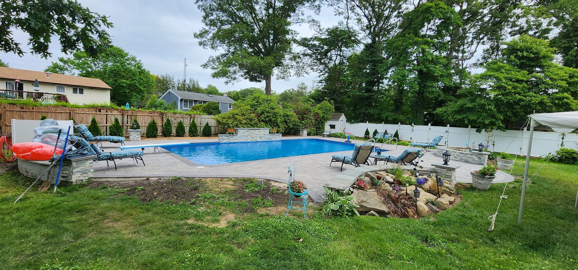 There is a large swimming pool in the backyard of a house.