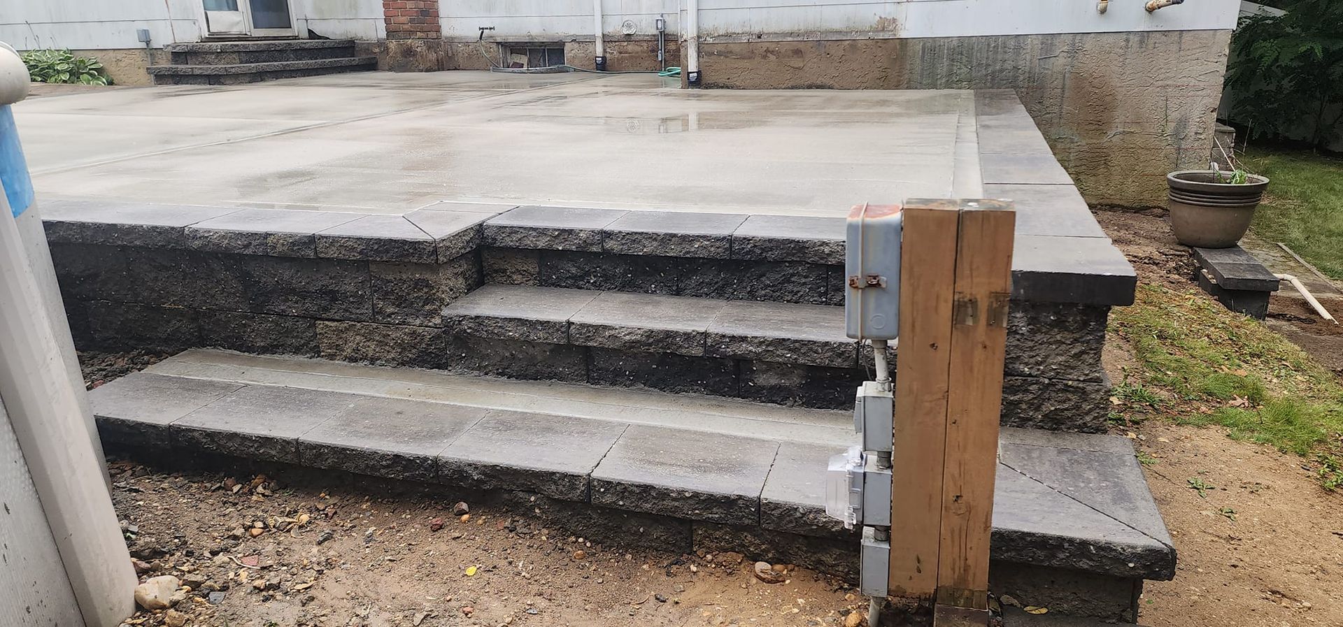 A set of stairs leading up to a concrete patio.
