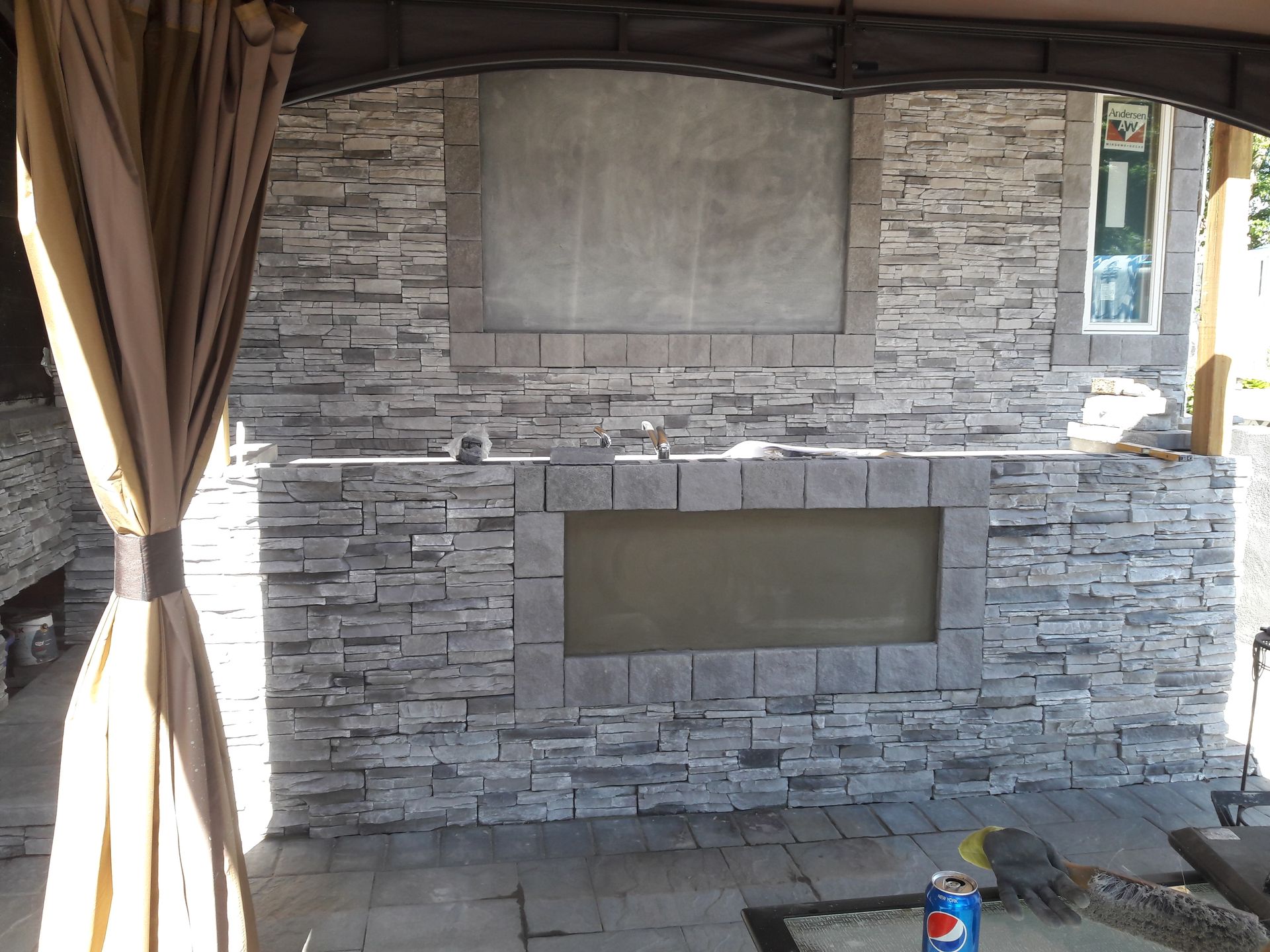 A stone wall with a fireplace in the middle of it