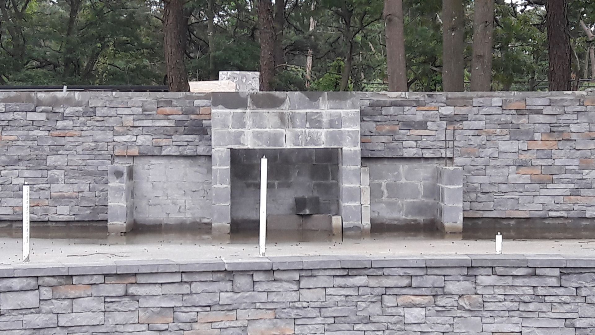 A stone wall with a fireplace in the middle of it
