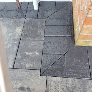 A close up of a brick walkway with a brick wall in the background.