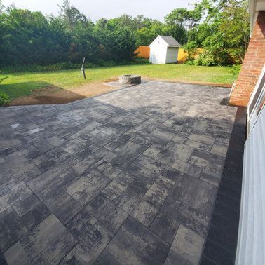 A patio with a fire pit in the backyard of a house.