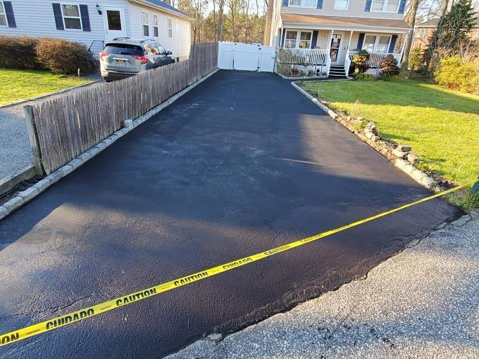 A driveway with a yellow caution tape along the side of it.