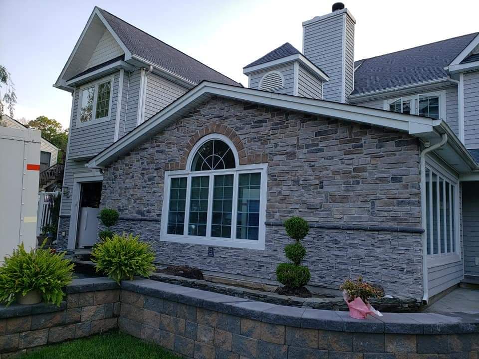 A large house with a stone facade and a lot of windows.