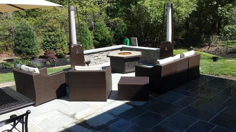 A patio with wicker furniture and a fire pit