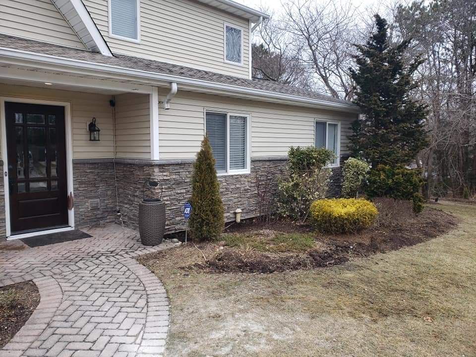 A house with a brick walkway leading to the front door.