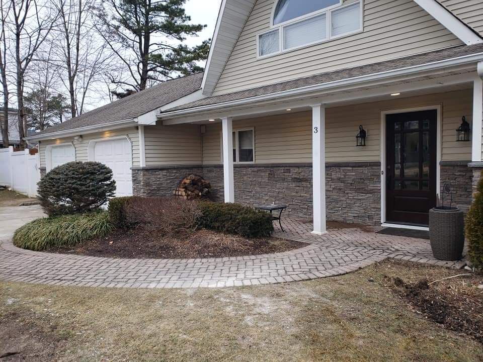 A house with a brick walkway leading to the front door