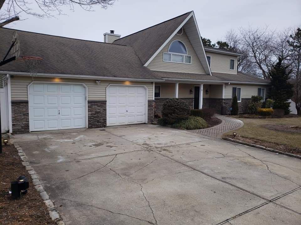A large house with two garage doors and a driveway
