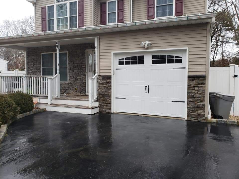 A house with a white garage door and a black driveway