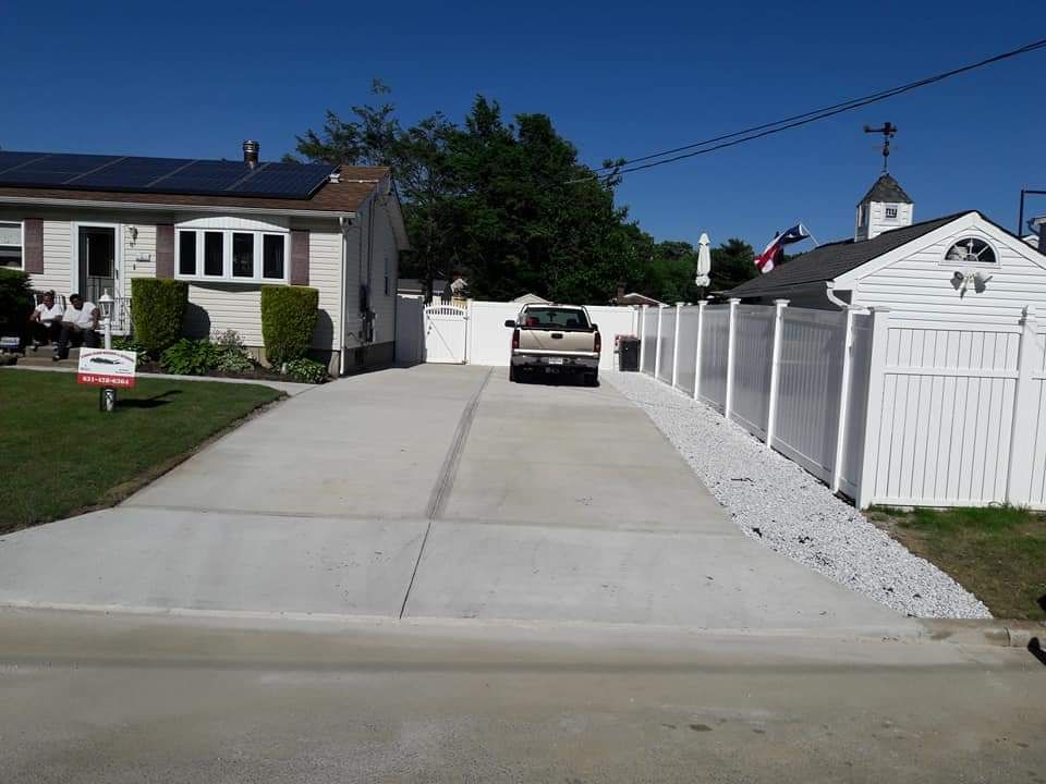 A car is parked in a driveway next to a house