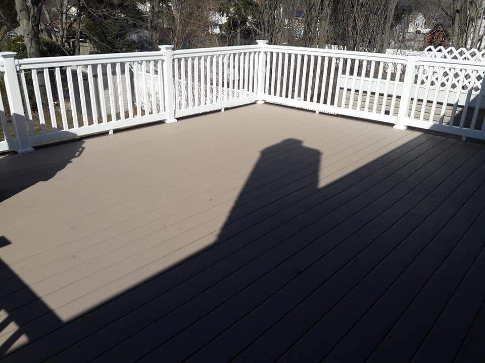 A deck with a white railing and a shadow on it