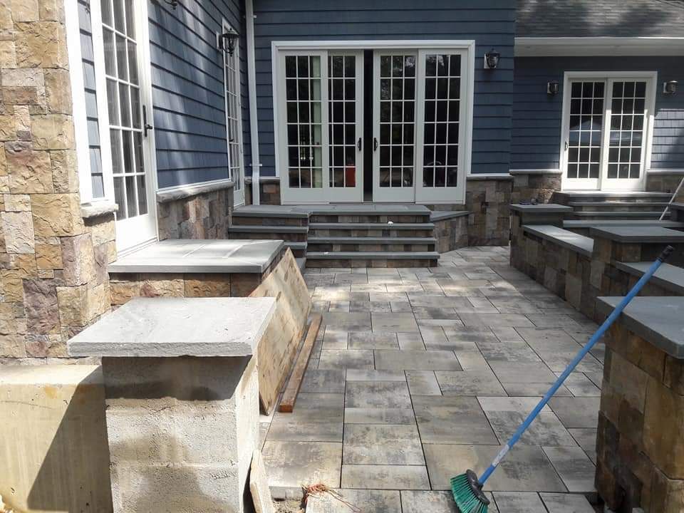 A broom is sitting on a patio in front of a house