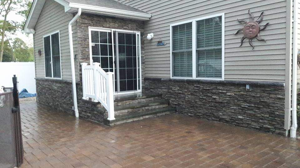 A house with a patio and a sun on the side of it.