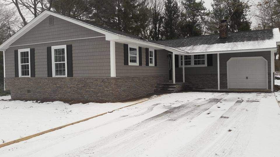 A house with a garage and a driveway covered in snow.
