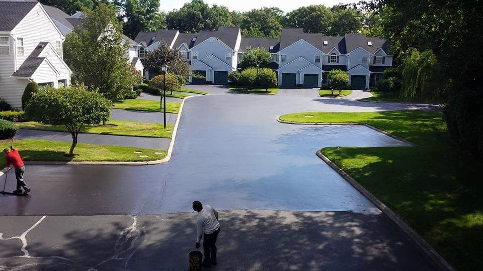 A man is cleaning a driveway in a residential area