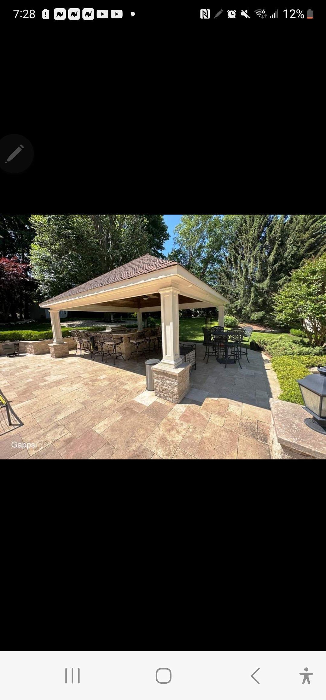 A picture of a pavilion in the middle of a yard.