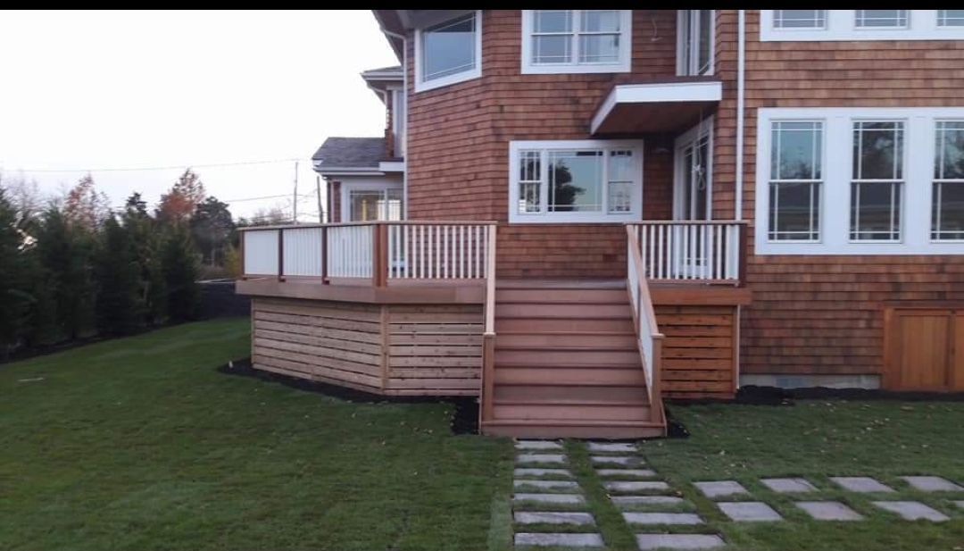 A large house with a wooden deck and stairs leading up to it.