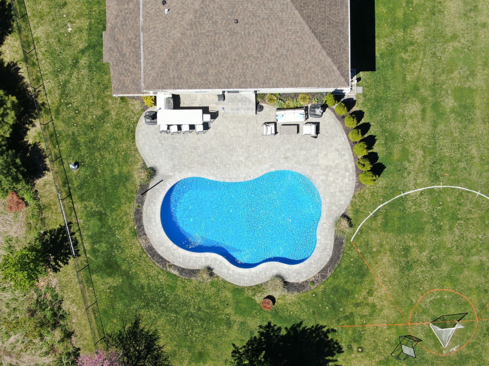 An aerial view of a house with a large swimming pool