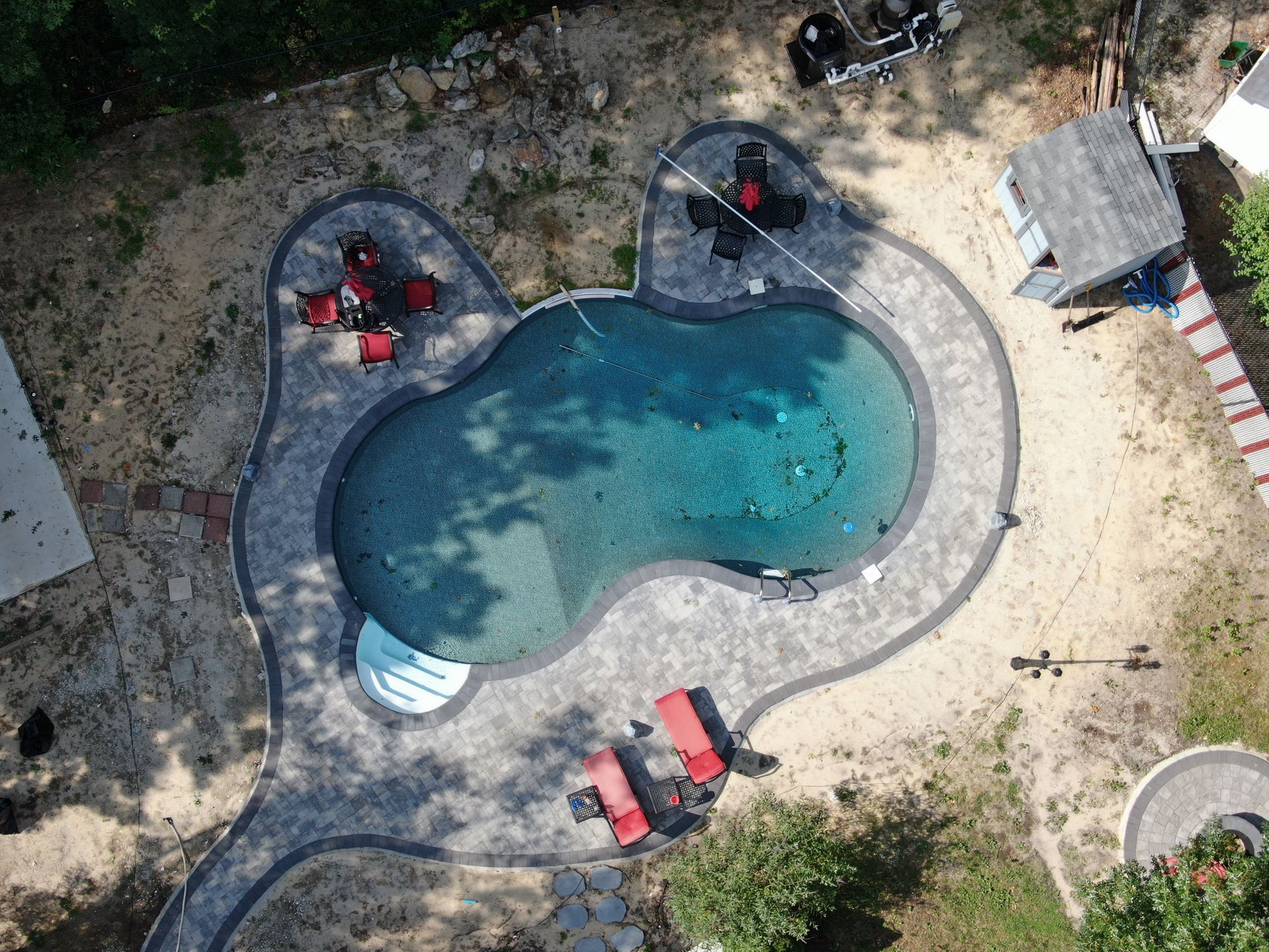 An aerial view of a large swimming pool in a backyard.