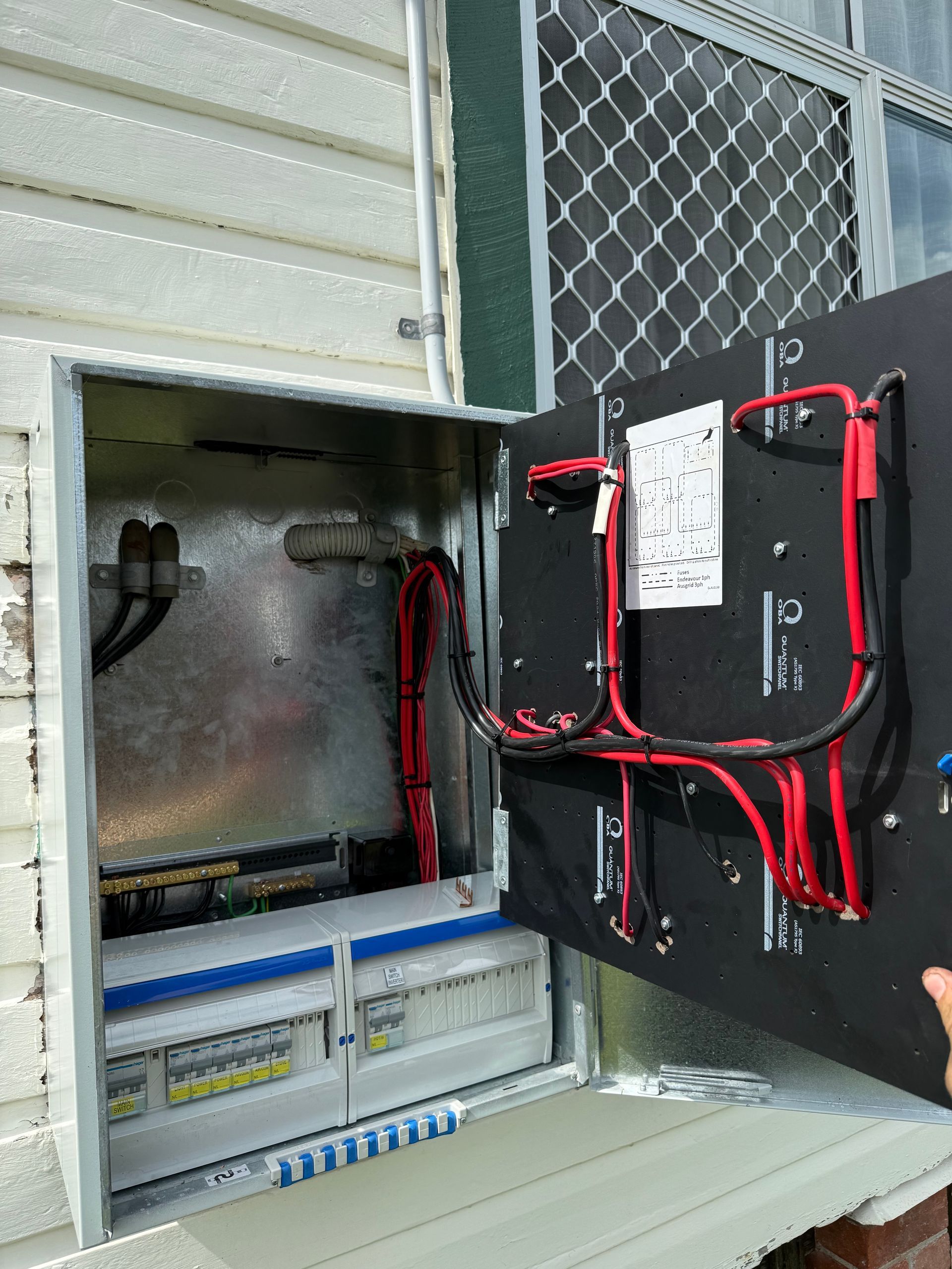 Opened Electrical Box With Wires, Breakers, and a Hinged Panel — CDT Electrical in Ballina, NSW