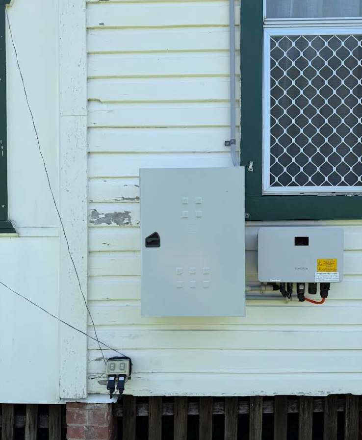 Solar Panel Components Mounted on a Cream-colored Building Exterior — CDT Electrical in Lennox Head, NSW