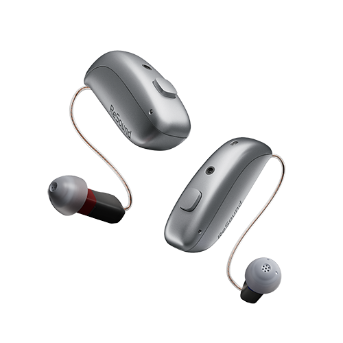 A pair of hearing aids are sitting next to each other on a white background.