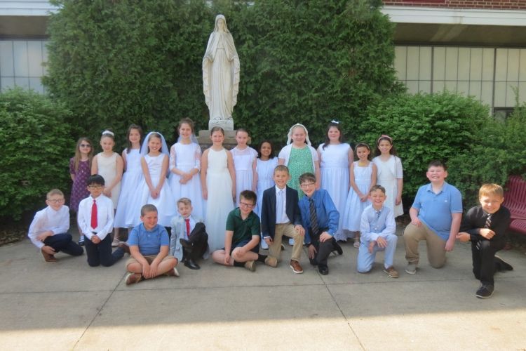 A group of children posing for a picture in front of a statue