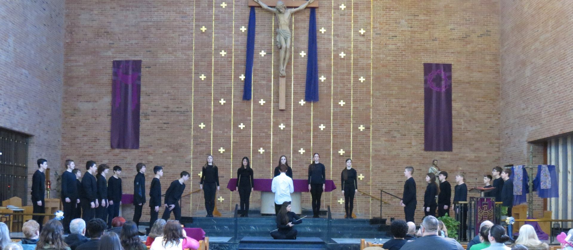 A group of people standing in front of a crucifix in a church