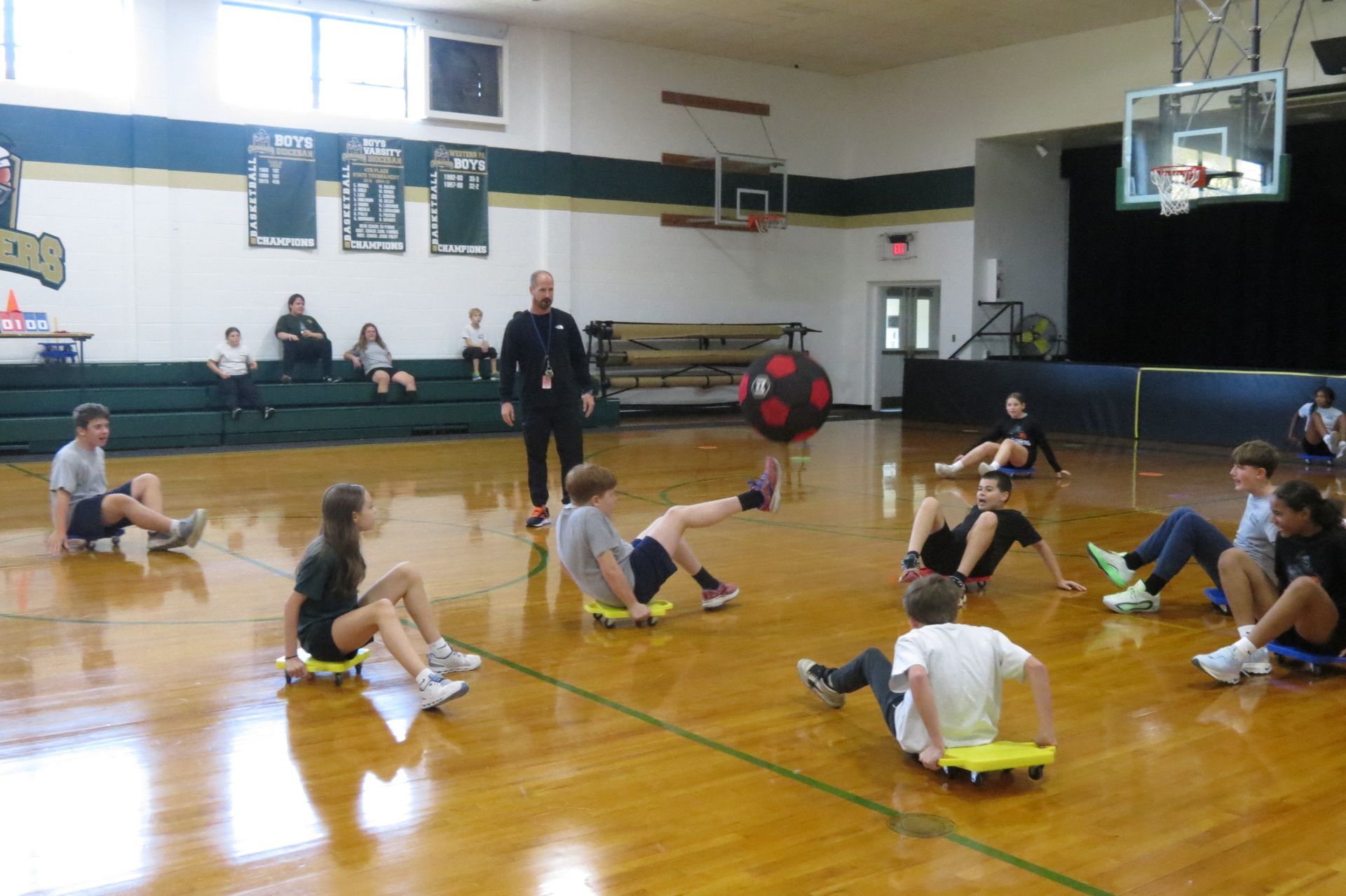 A group of children are playing a game in a gym