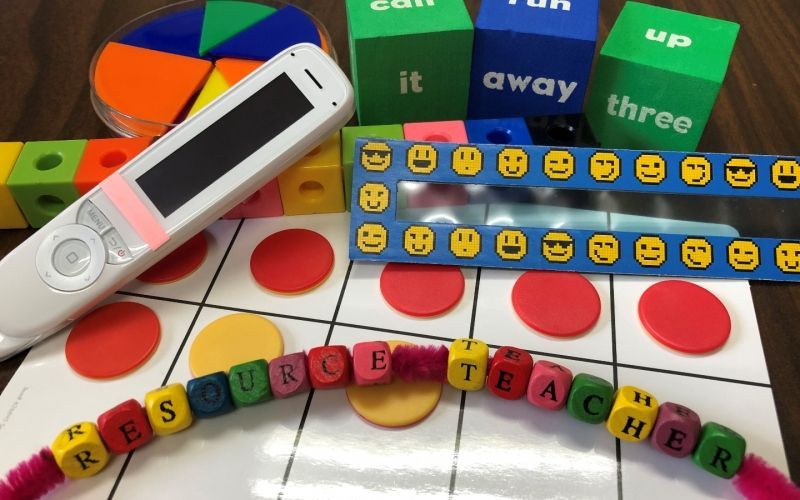 A bunch of toys on a table including one that says resource teacher