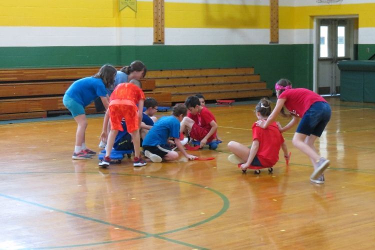 A group of children are playing a game in a gym