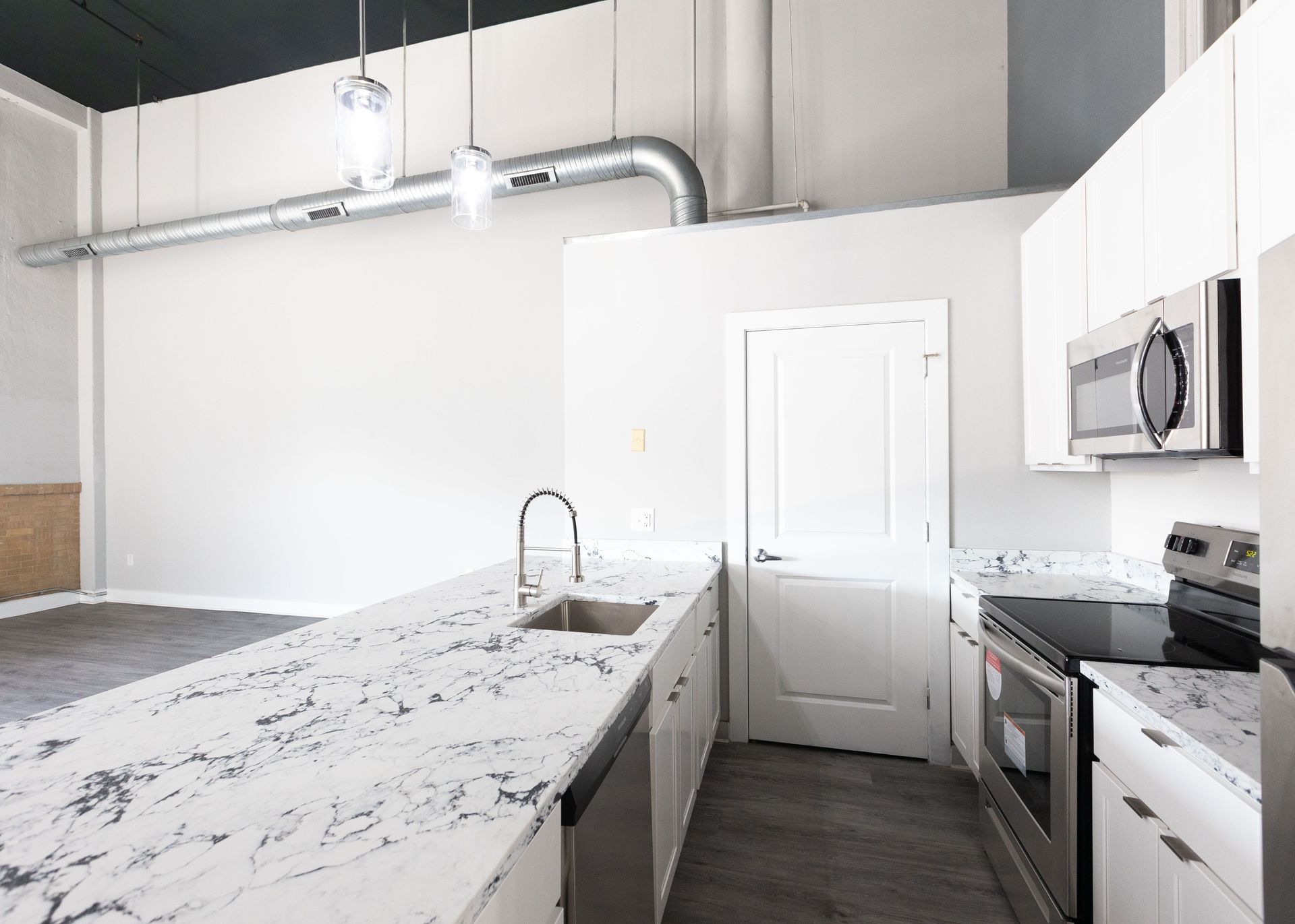a kitchen with white cabinets , granite counter tops , stainless steel appliances and a sink .
