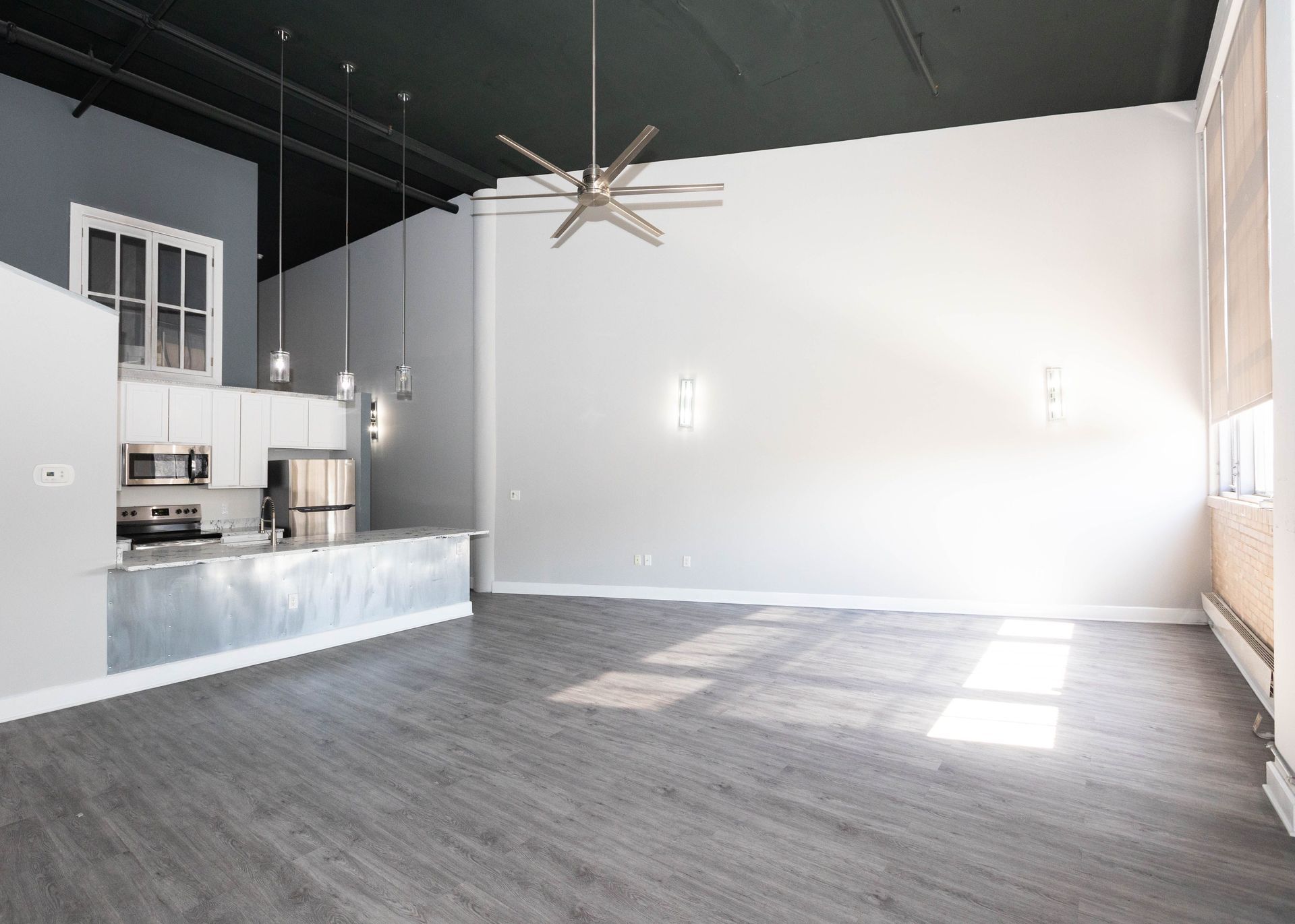 an empty kitchen with a ceiling fan hanging from the ceiling .