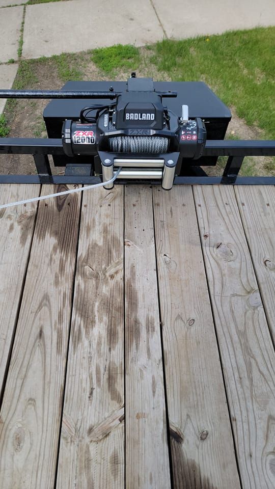A winch is sitting on top of a wooden deck.