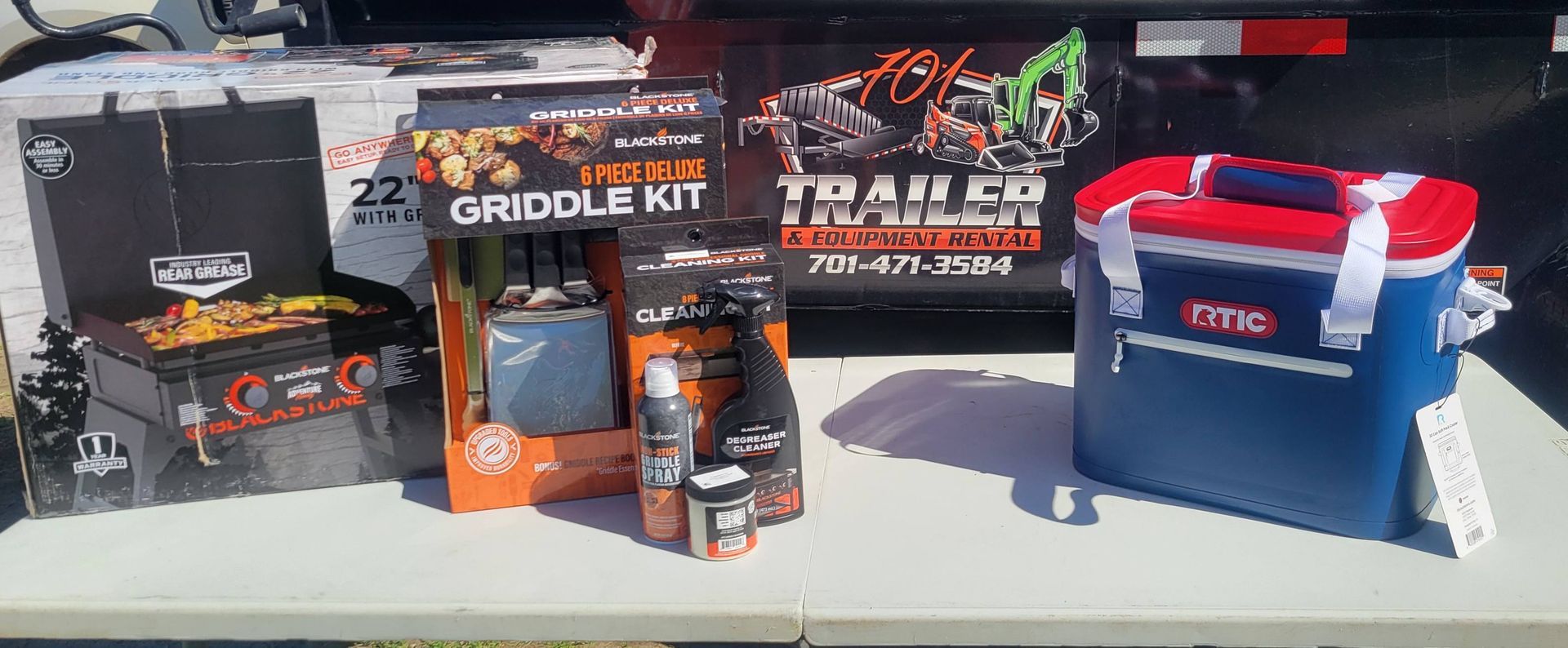 A table with a grill and a cooler on it.