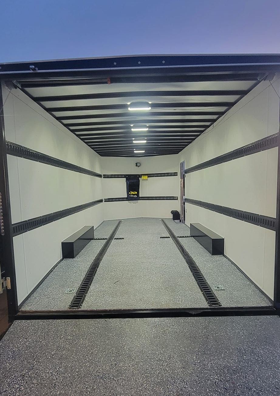 The inside of an empty trailer with the door open.