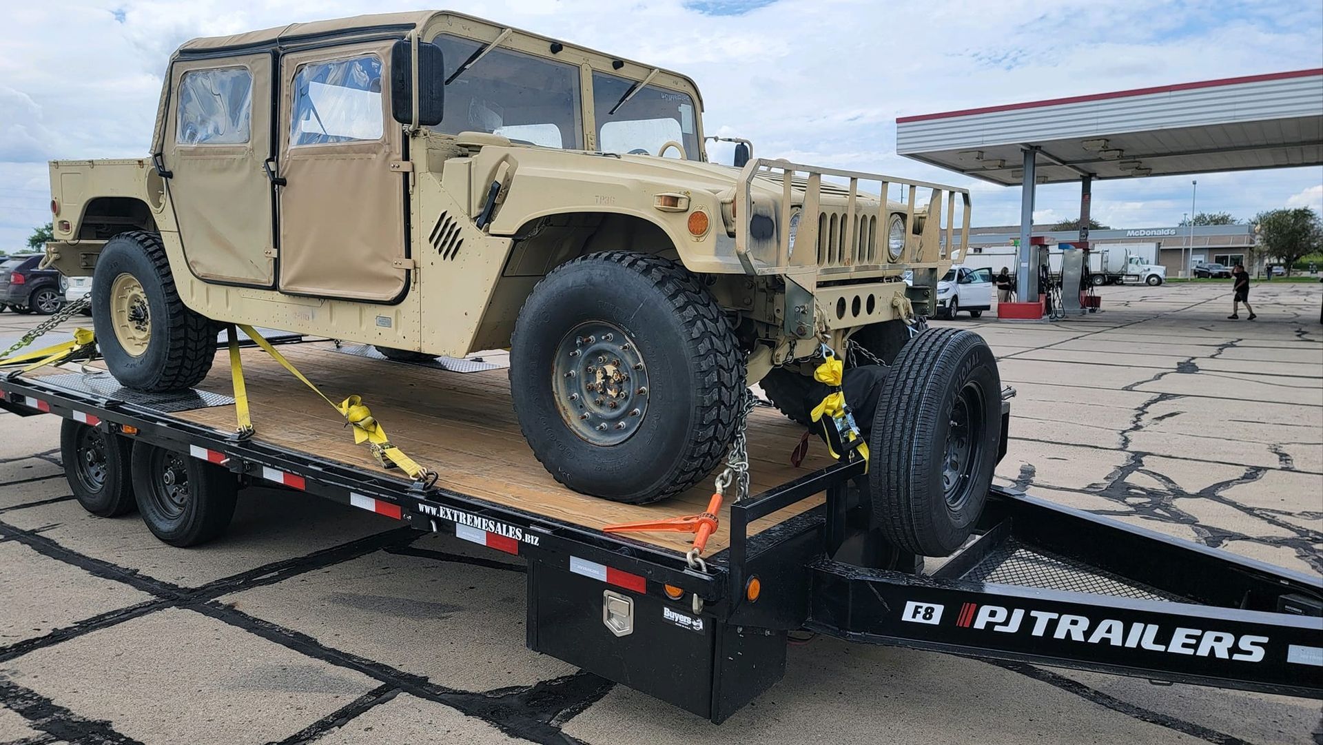 A military vehicle is sitting on top of a trailer.