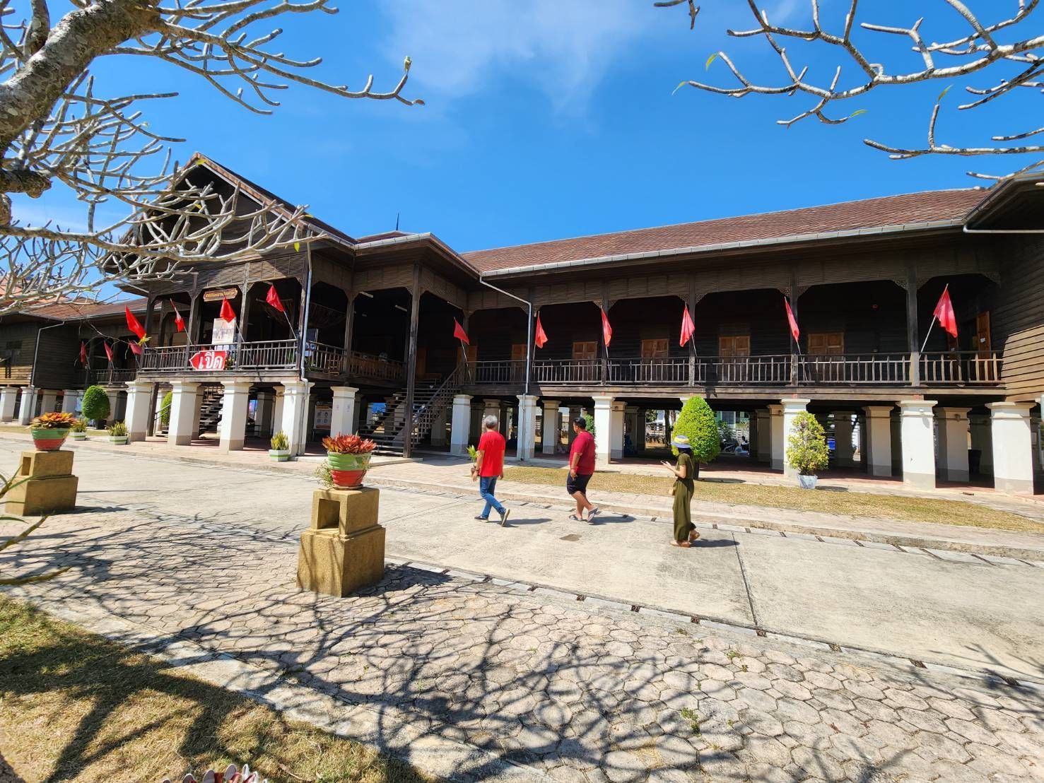 A large wooden house with a cross in front of it