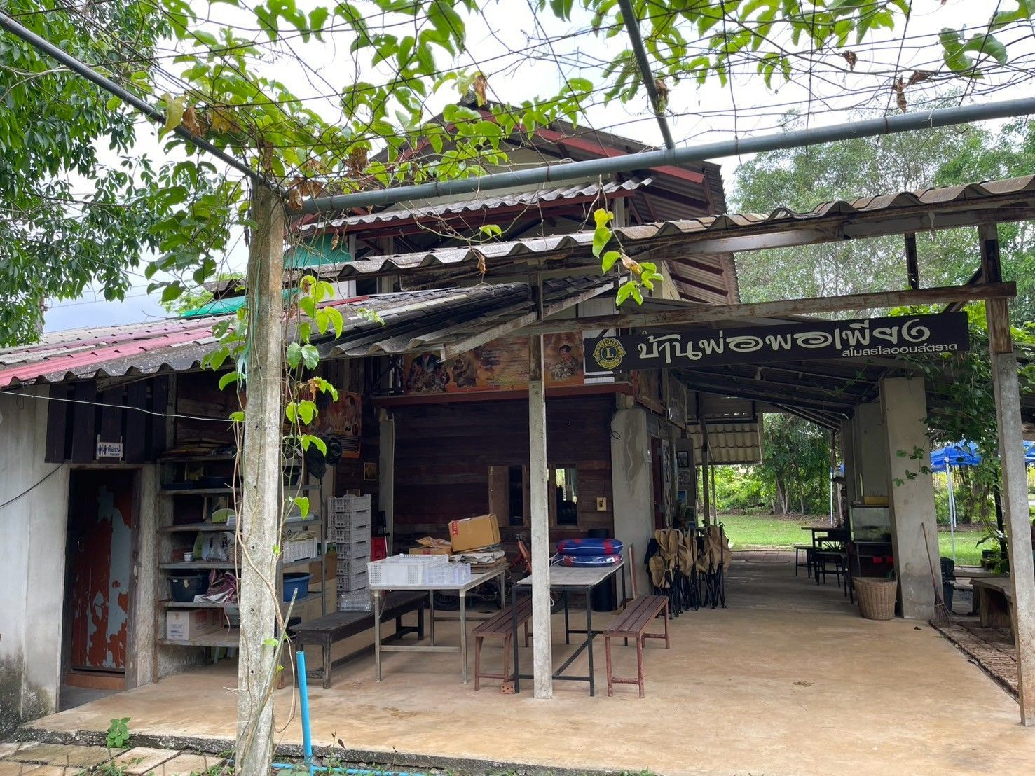 A restaurant with tables and chairs under a roof.
