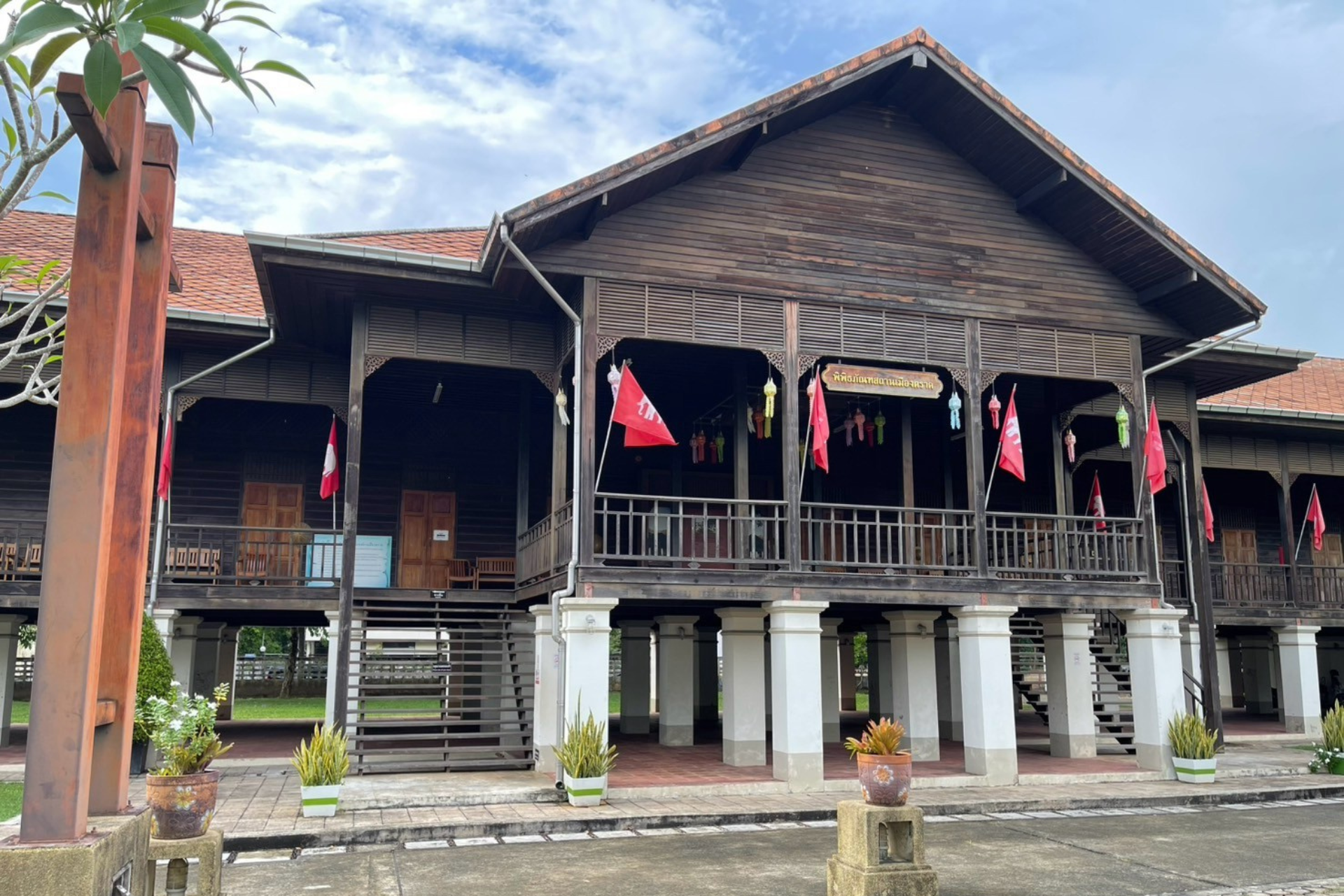 A large wooden house with a cross in front of it