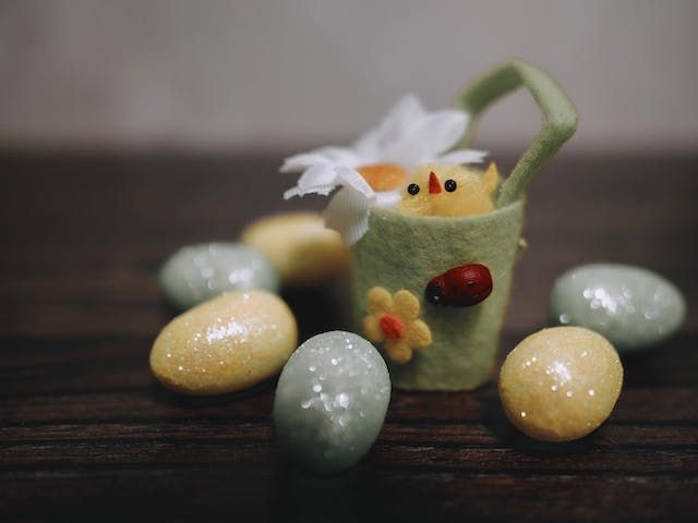 Easter eggs and a chick in a basket on a table