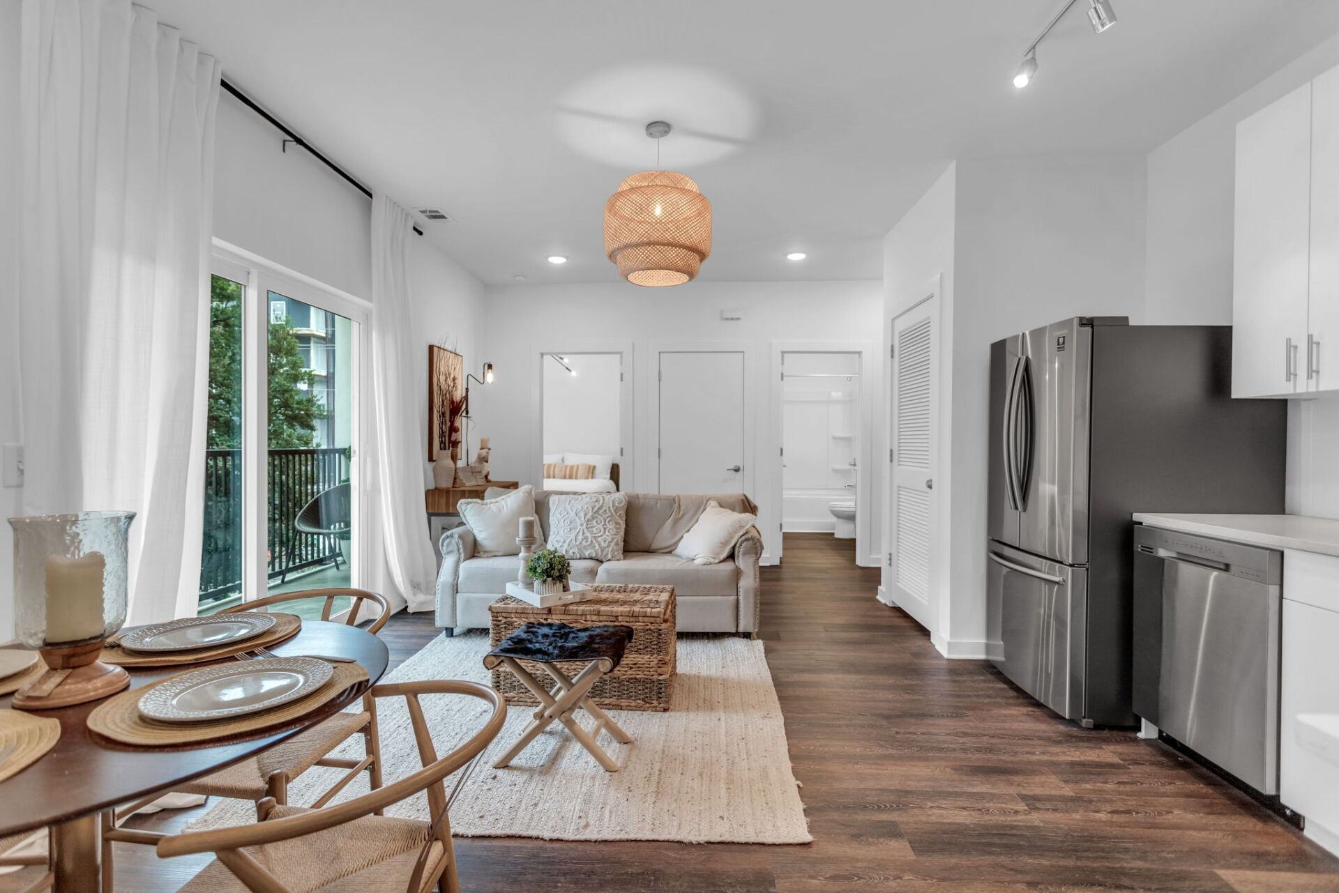 A living room with a couch , table , chairs and a refrigerator.