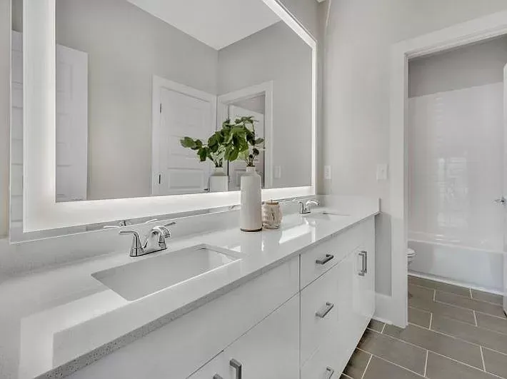 A bathroom with two sinks and a large mirror.