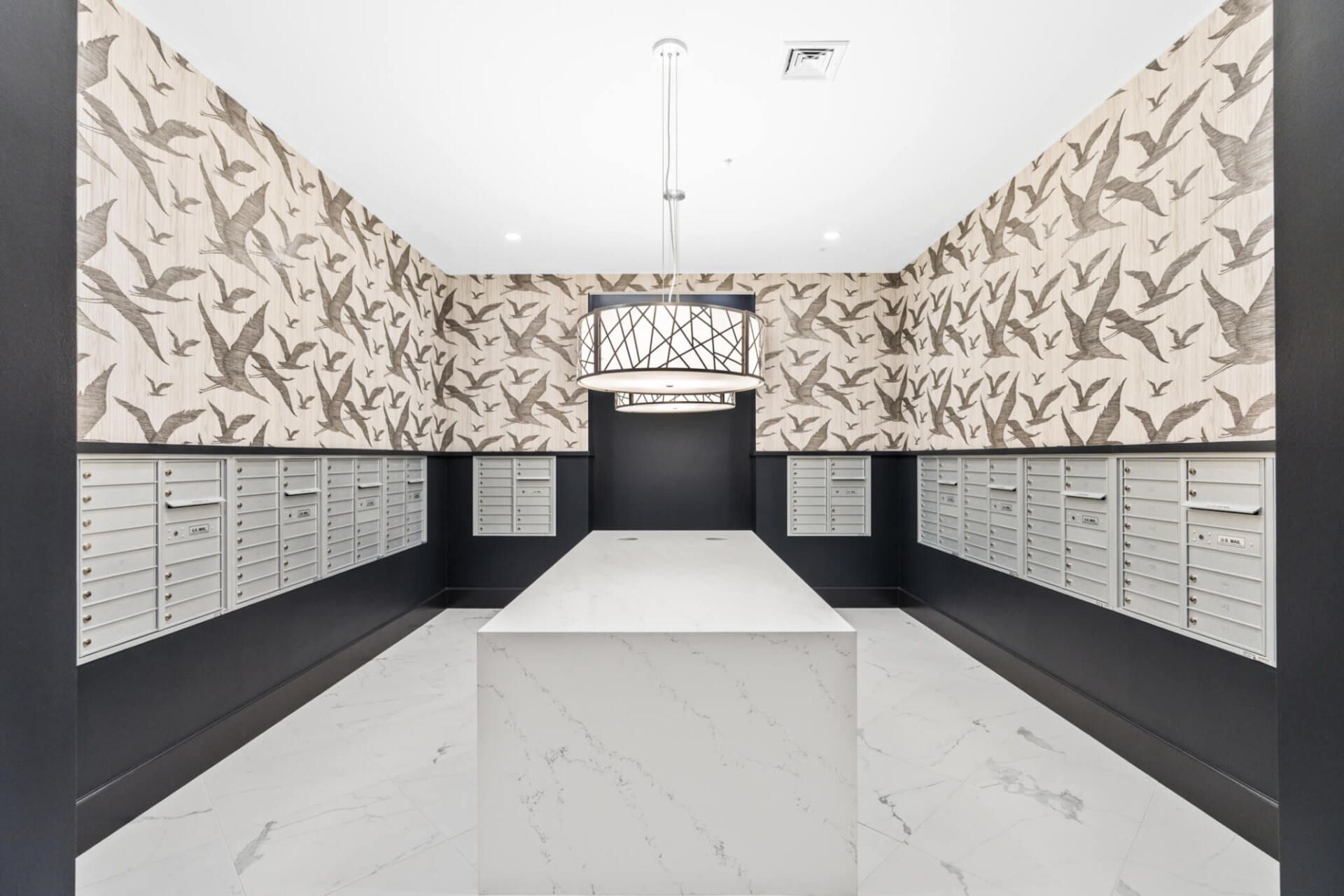 A room with a lot of mailboxes and a table in the middle.